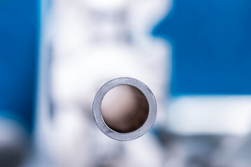 Single aluminum pipe, cross section view, with blurred background