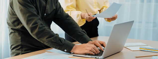 Professional architect edited blueprint by using laptop while project manager point the mistake...