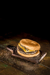 Hamburguer com carne, queijo derretido, sobre fundo de madeira