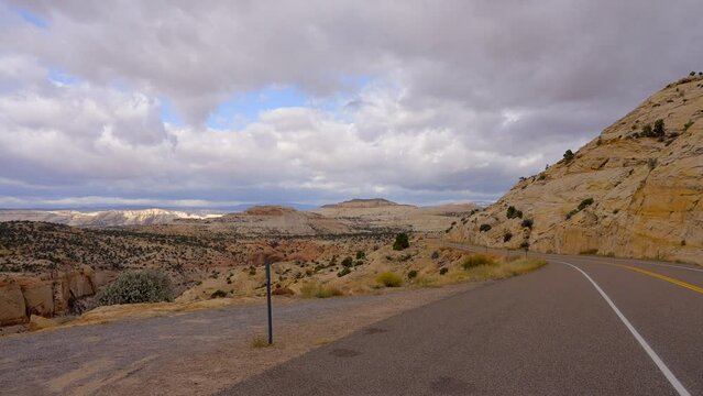 Establishing shot of brown mountains with green forest in The Hogback Scenic Root 12, Utah, North America. Day time on October 2023. ProRes 422 HQ.