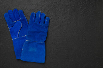 Blue construction gloves on concrete background, top view