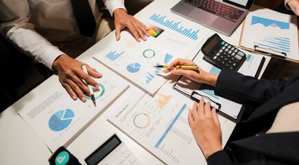 Group of confident business people point to graphs and charts to analyze market data, balance...