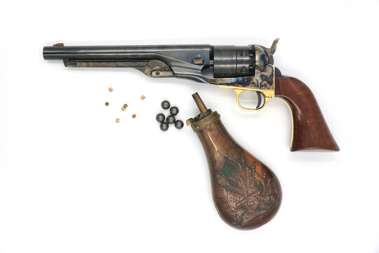 Black powder percussion revolver Colt 1860 Army and the equipment such as a gunpowder flask, lead balls and percussion caps on a white background. Left side.