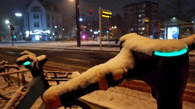 Snowy winter night with escooter or emobility bike sharing concepts in snowy city streets shows environmental friendly mode of transportation in snowfall as electric vehicle in modern city life safety