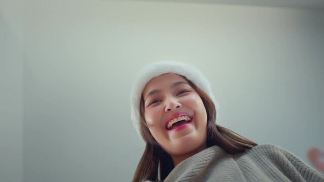 Happy excited young asian woman wearing a Santa hat unbox parcel, Surprise female looking inside Christmas gift with smile, joy, amazement, opening package, Christmas and new year.