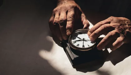 Crédence de cuisine en verre imprimé Vielles portes elderly man holding old and antique clock in his hands watches how time passes