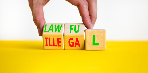 Lawful or illegal symbol. Concept word Lawful or Illegal on wooden cubes. Beautiful yellow table white background. Businessman hand. Business lawful or illegal concept. Copy space.