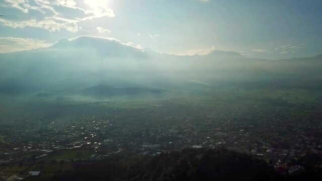 HD aerial video of the Magical town of Amecameca, State of Mexico, passing through the center of the town and in the background the Iztacihuatl Volcano at dawn.
