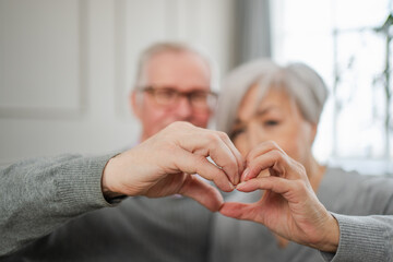 Love heart shape peace. Senior older couple making heart shape with their hands. Adult mature old...