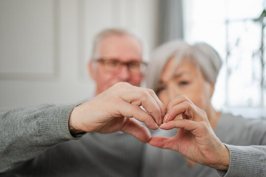 Love Heart Shape Peace. Senior Older Couple Making Heart Shape With Their Hands. Adult Mature Old Husband Wife Showing Heart Sign. Happy Pensioner Family. I Love You Happy Valentines Day