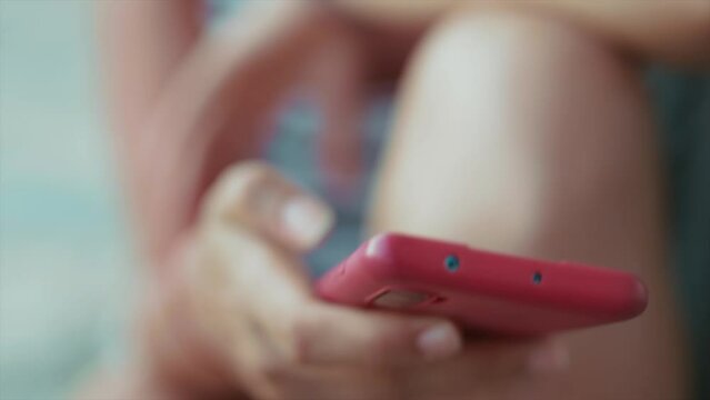 A woman is holding her phone and scrolling through information on various social media platforms