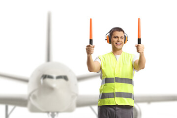 Aircraft marshaller signaling with wands in front of a plane