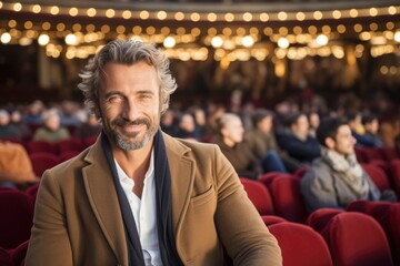 A Man Sitting in a Brown Jacket in a Theater - obrazy, fototapety, plakaty