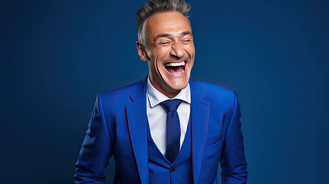 An image of a middle-aged laughing man dressed in a suit on a cobalt blue background with confidence and charm. 