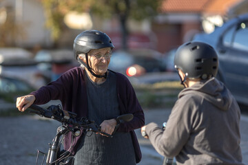 two elderly women riding an electric bicycle and scooter