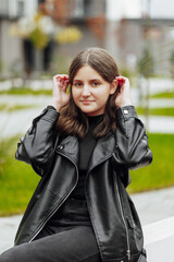 Vertical photo. Beautiful carefree young teenage girl in casual clothes. Portrait of a beautiful girl against the background of nature with a blurred background.