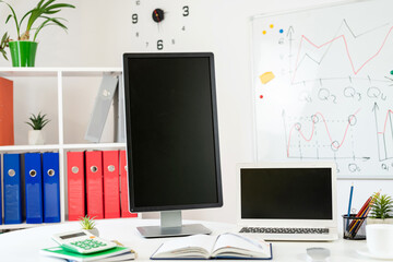 Workplace without people pc laptop pen notepad and whiteboard wit hbusiness graph