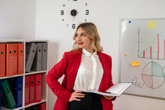 Businesswoman standing near a chartboard and working on business plan company development in office