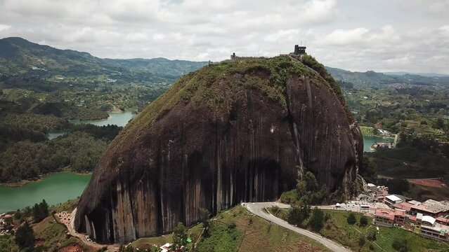 Aerial drone footage of El Penon de Guatape near Medellin in Antioquia, Colombia. Large and unique alone rock with stairs to the top, touristic place. Big stone in Colombia. High quality 4k footage.