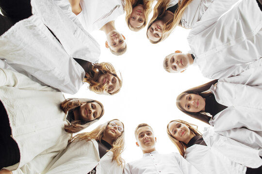 Large Group Of Smiling Young People Standing, Hugging, Looking At Camera. Group Of Cheerful Teenage People In A Circle Looking Down. Low Viewing Angle. Copy Space.