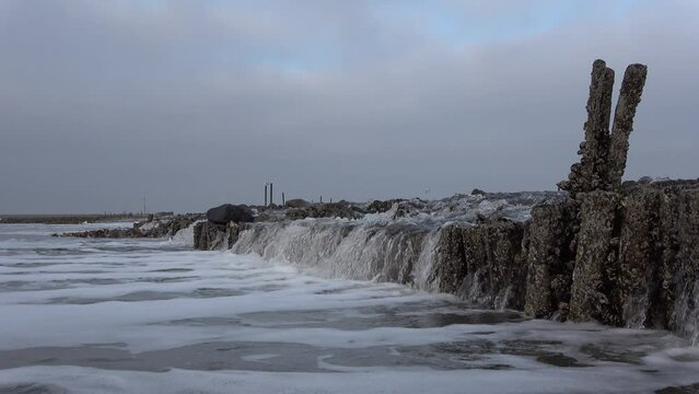 Wasserfall durch Gezeitenstr&ouml;mung im Wattenmeer mit wilden Austern- und Miesmuschelb&auml;nken, Priel, Ebbe, Nordsee