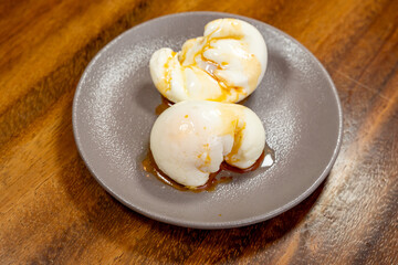 two poached eggs on a plate with olive vegetable oil