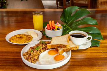 Colombian breakfast with arepas, coffee, bread, eggs, warmed rice and fruit