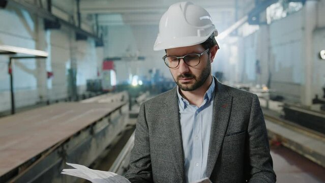 Caucasian man investor holding new project work of industrial production zone he looking around and have a thinking face he wearing safety helmet