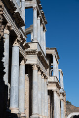 Panoramic view of the ancient Roman theater ruins of Merida, Spain under clear blue sky.