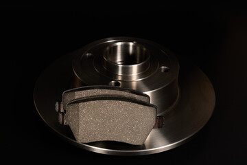 New brake disc with brake pads on a black background.