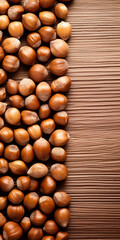 Hazelnuts spilled on light wood table, overhead view, bright light