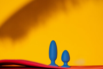 Collection of different types blue anal plugs of sex toys on yellow background. Sex toy for adult. Copy space
