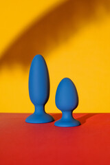 Collection of different types blue anal plugs of sex toys on yellow background. Sex toy for adult. Close up