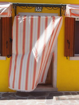 Porte et rideaux rouges et blancs, mur jaune, &agrave; Burano (Venise, Italie)