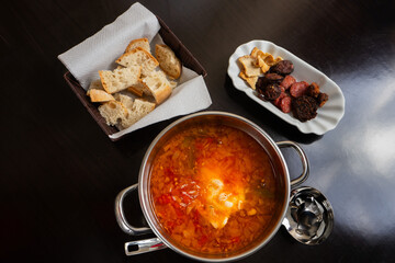Delicious Alentejo tomato soup with fried sausages, served in a rustic restaurant setting.