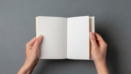 hands holding open square book or album with blank pages cut out