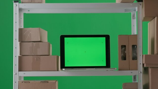 The frame is on a green background. It depicts an empty room with stylings on which stand boxes and a laptop with a green screen. No people in the room. Space for advertising. Medium frame