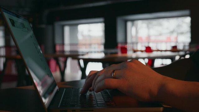 Close-up, a hacker or Internet fraudster opens a laptop and starts working, typing text on the keyboard. There is only a laptop and hands in the frame. An unrecognizable face. High quality 4k footage
