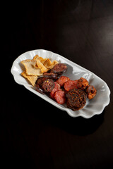 Fried Alentejo sausages and bacon ready for tomato soup—a savory delight from a Portuguese restaurant.