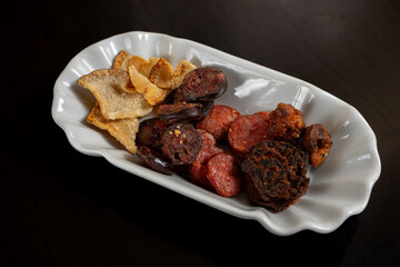 Fried Alentejo sausages and bacon ready for tomato soup—a savory delight from a Portuguese restaurant.
