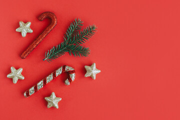 Spruce branch and Christmas ornaments on a red background. Holiday concept.