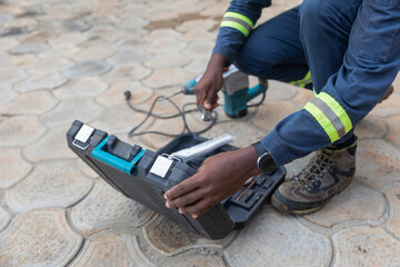 Closeup of an African plumber putting his tools away after a day's work
