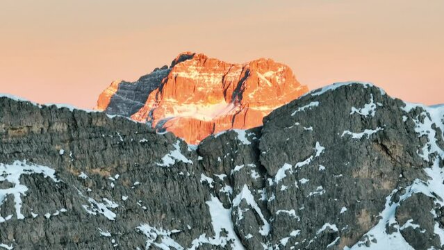 Il monte Pelmo illuminato dal sole compare all'orizzonte, quando il drone supera la roccia dolomitica, italia, 4k