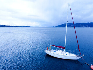 Sailboat in the sea in the evening over beautiful big mountains background