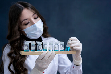 female laboratory worker holding experimental medicine flask liquid inside