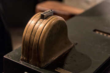 coin slot in old subway turnstile detail (macro photo of antique fare collection meter) metro ticket, token (nostalgia, retro, vintage, historic, historical) nyc commuter rail system