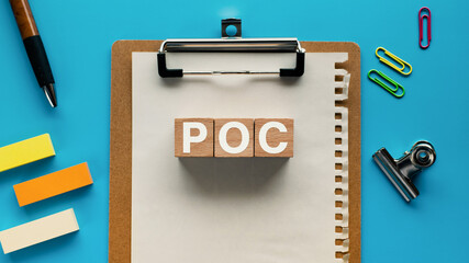 There is wood cube with the word POC. It is an abbreviation for Proof of Concept as eye-catching...