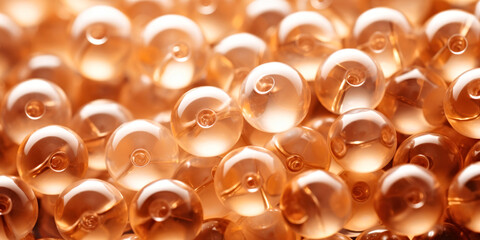 A close up of a bunch of gold beads. Monochrome peach fuzz background.