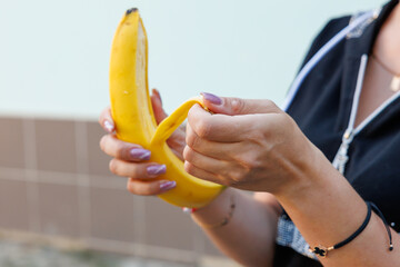 Woman's hand holding bananas, snack and fast food concept. Selective focus on hands with blurred background
