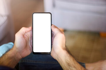 Male hands hold a sleek mobile phone with a blank screen, offeri